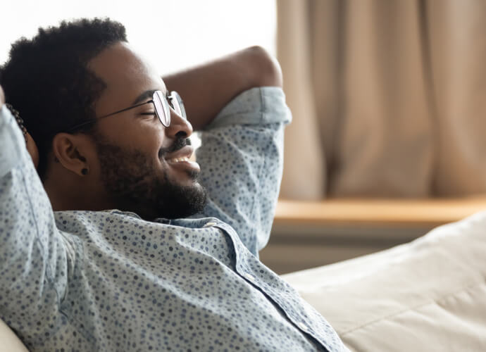 Uomo sorridente seduto su un divano